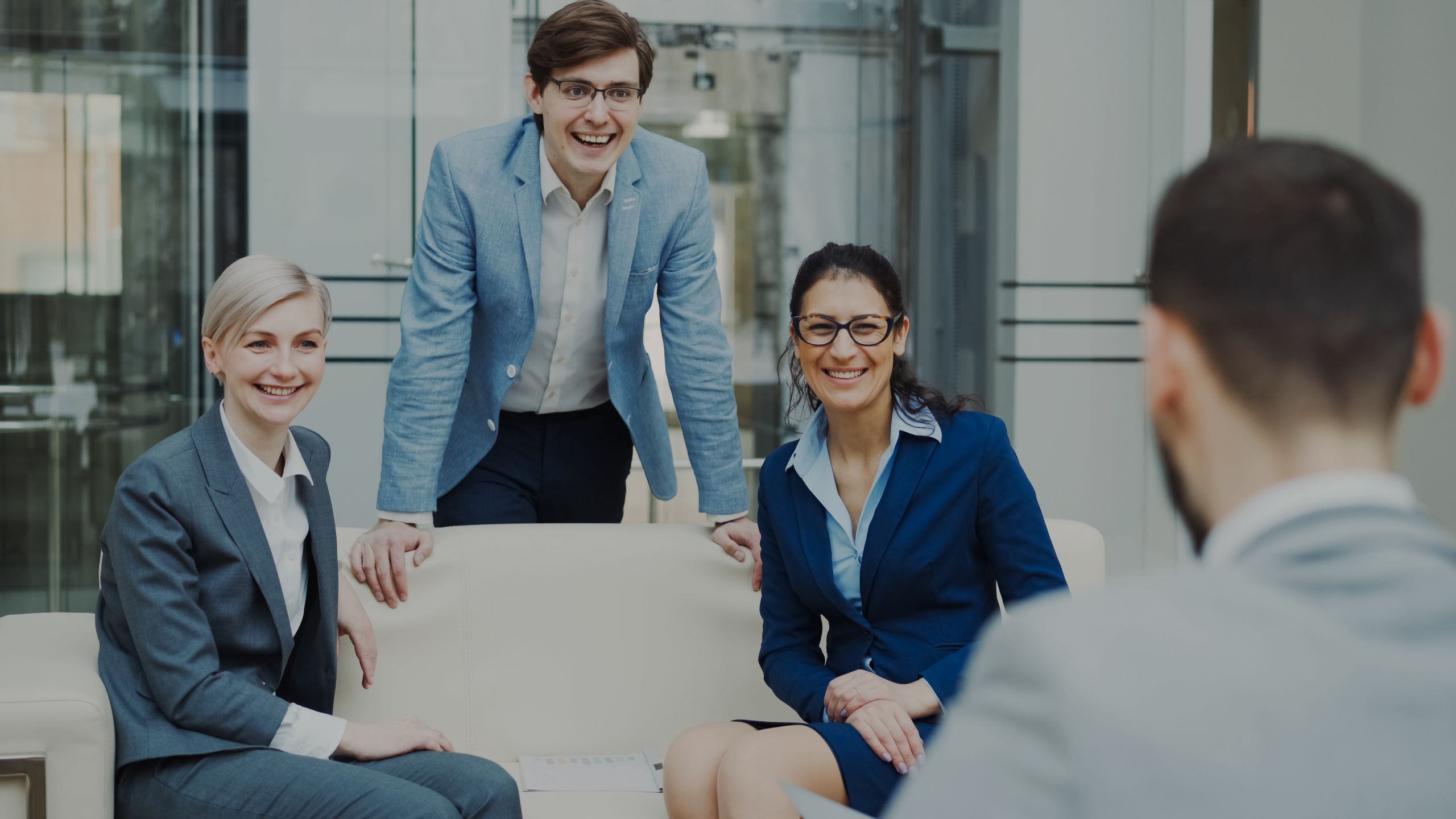 Professional team of adults in a business meeting setting in a modern office environment.